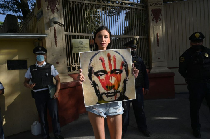 A member of the Ukrainian community holds a banner depicting Russian President Vladimir Putin