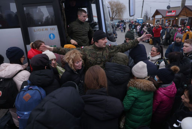 A Polish border guard urges people from war-torn Ukraine to step back