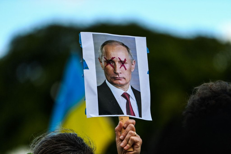 A demonstrator holds a sign depicting Russian President Vladimir Putin