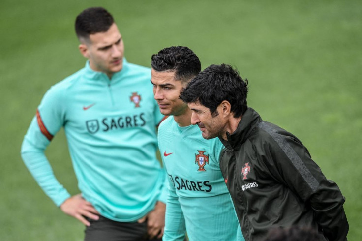 Portugal's forward Cristiano Ronaldo (C) and Portugal's defender Diogo Dalot (L) attend a training session