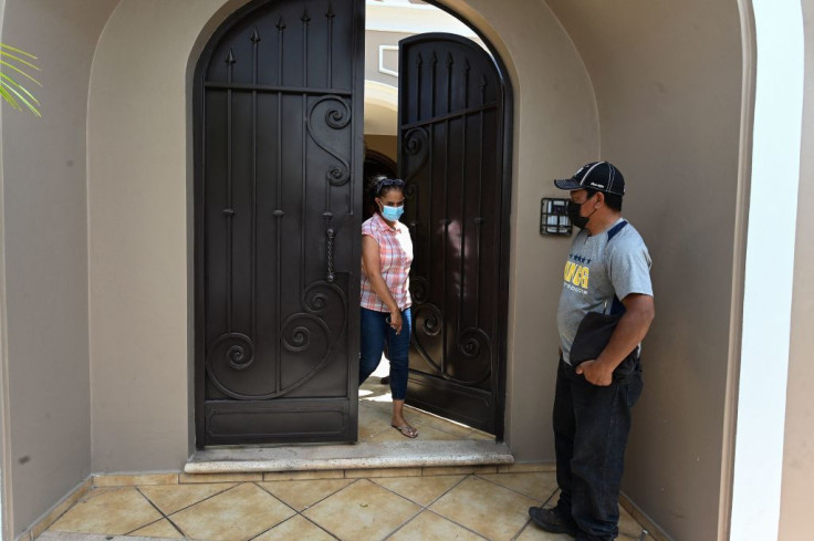 A woman exits Honduran former President Juan Orlando Hernandez's residence