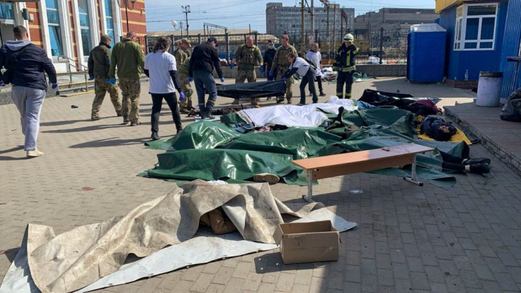 Ukrainian servicemen carry a victim to be placed next to other casualties