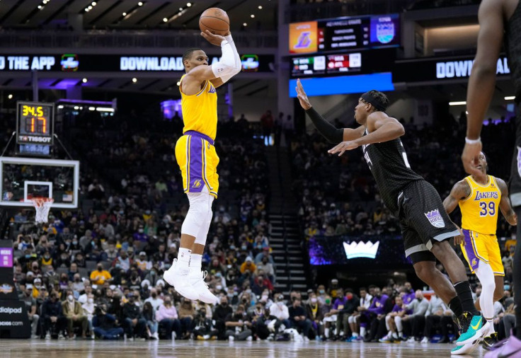 Russell Westbrook #0 of the Los Angeles Lakers shoots a three-point shot over Buddy Hield #24 of the Sacramento Kings