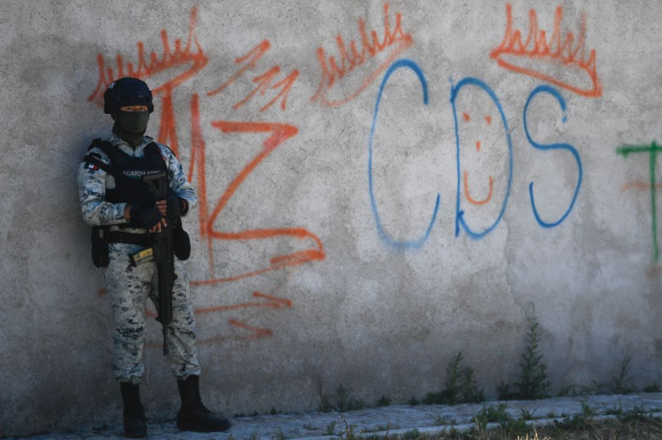 A Mexican soldier stands guard next to some graffitis of the drug trafficker Mayo Zambada