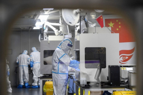 Laboratory technicians work on samples in Wuhan