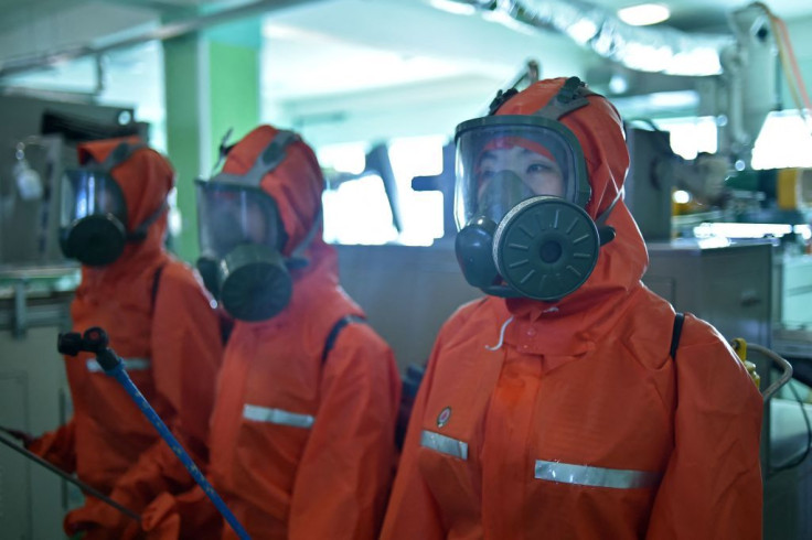 Health officials disinfect the work place at the Pyongyang Cosmetics Factory