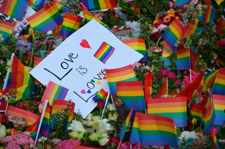 This photograph shows flowers and rainbow flags laid after a shooting near an LGBT bar in Oslo