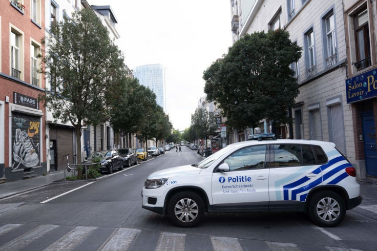 Belgian police officers patrol a closed street 