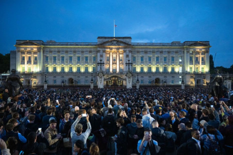 The Union flag flies half-mast as people gather at Buckingham Palace