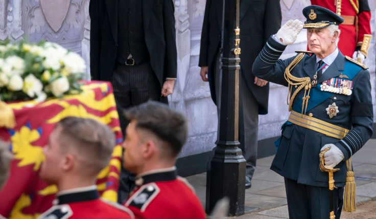 King Charles III, salutes as the bearer party carry the coffin of his mother, Queen Elizabeth II