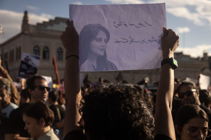 People hold signs and chant slogans during a protest against the death of Iranian Mahsa Amini