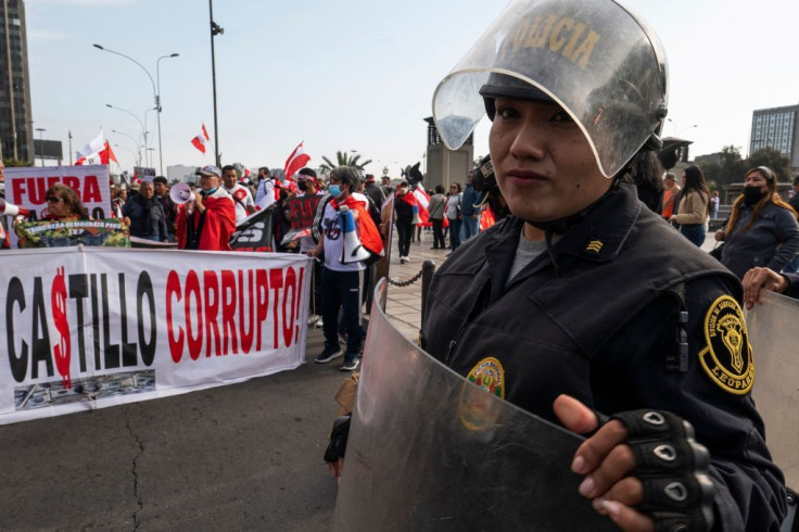 A member of the riot police stands guard as detractors of Peru's President Pedro Castillo hold a demonstration