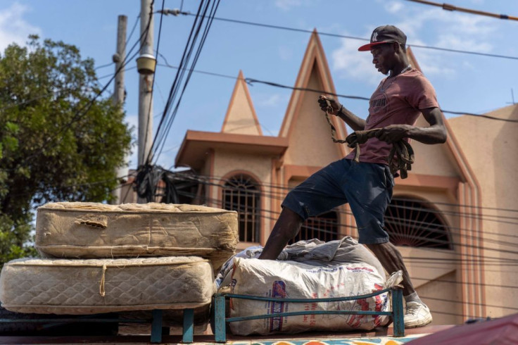 Haitians work in Port-au-Prince on October 29, 2022, one day after gunmen assassinated former presidential candidate Eric Jean Baptiste