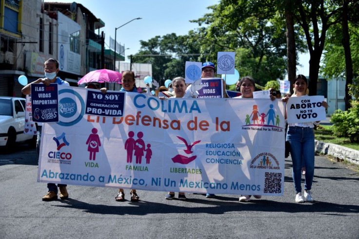 People hold a flag during a demonstration against abortion rights