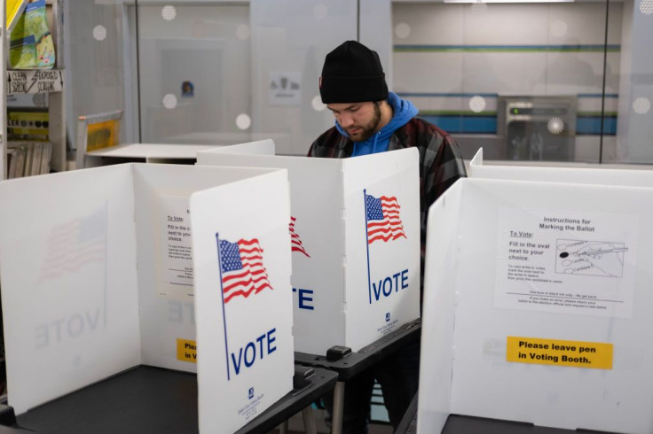 A voter casts their ballot at the Hillel Foundation