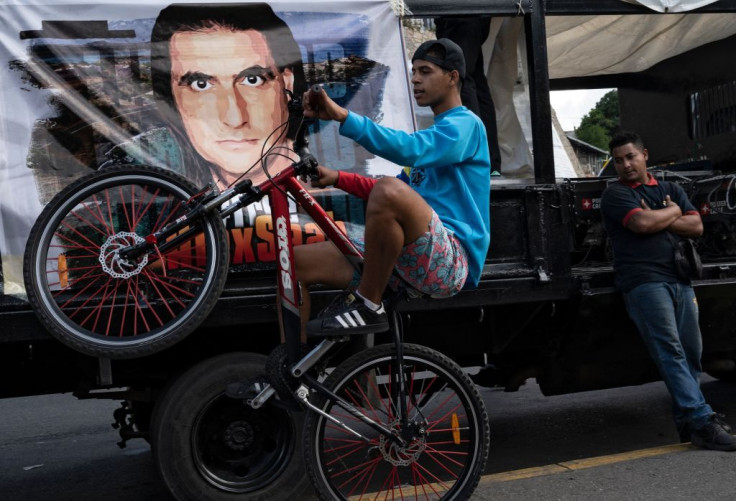 A young man performs a stunt while activists of the "Free Alex Saab" get ready for a movement 