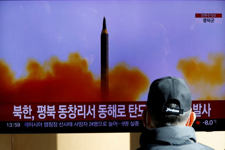 A man watches a TV broadcasting a news report on North Korea firing a ballistic missile off its east coast