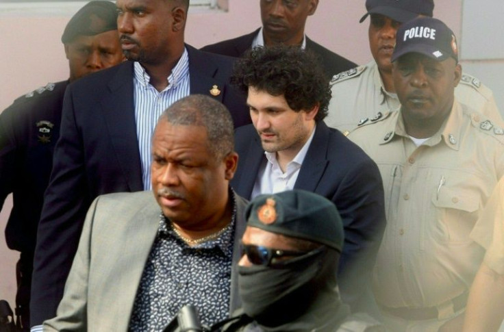 FTX founder Sam Bankman-Fried (C) is led away handcuffed from a Nassau