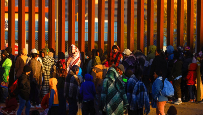 Migrants queue near the border fence