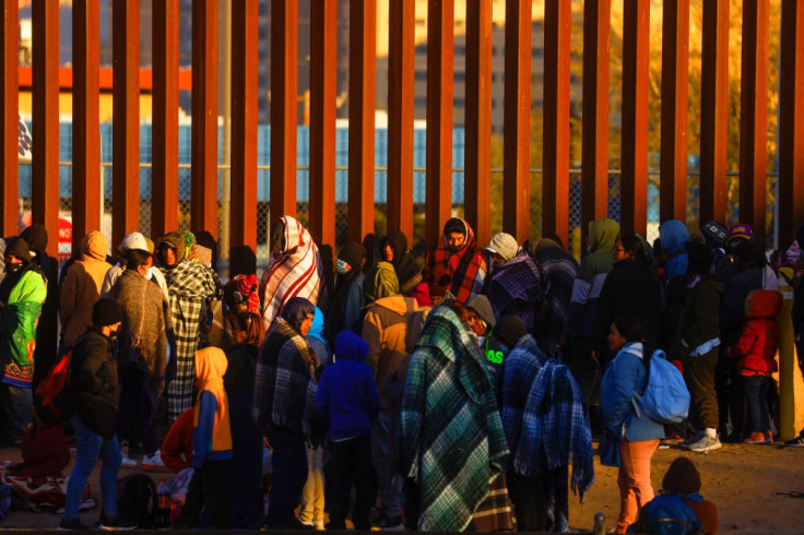 Migrants queue near the border fence