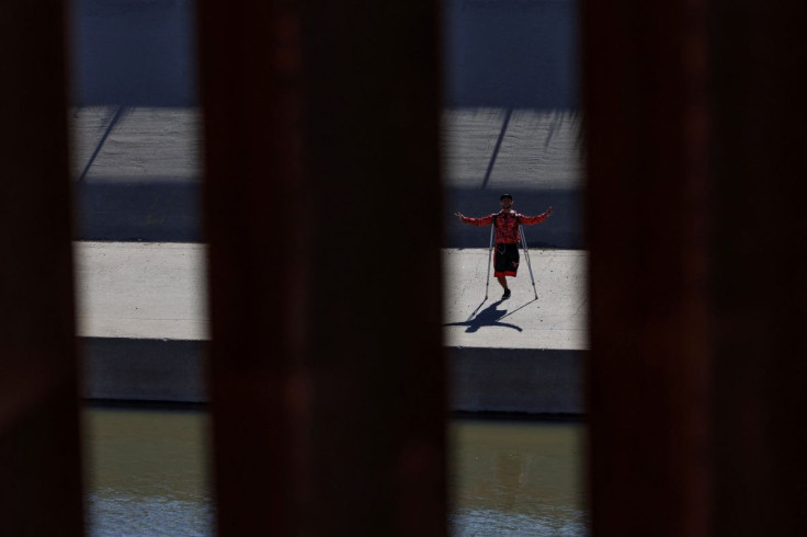 Asylum-seeking migrants wait at the border between Mexico and the U.S., as seen from El Paso