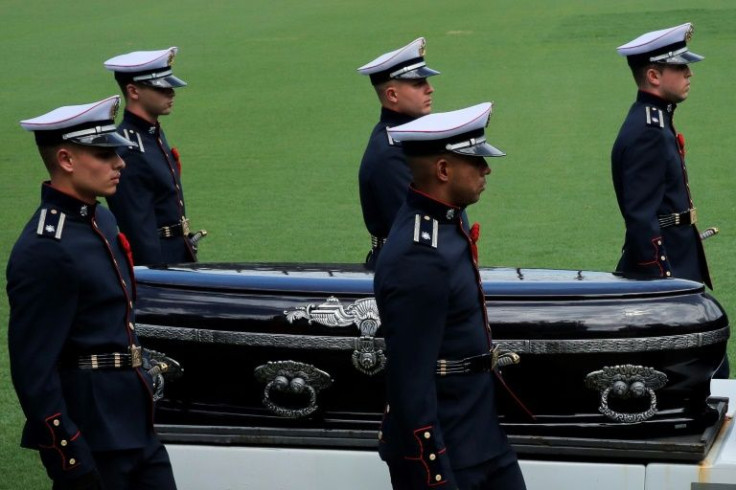 State police guards in dress uniform carry Pele's coffin