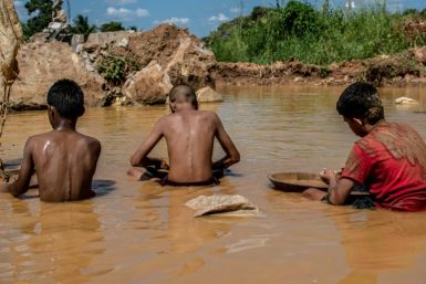 Venezuelan children work in a puddle