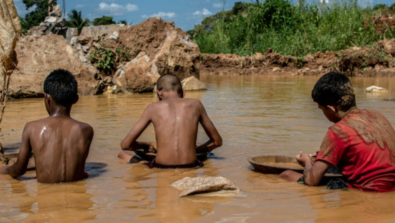Venezuelan children work in a puddle