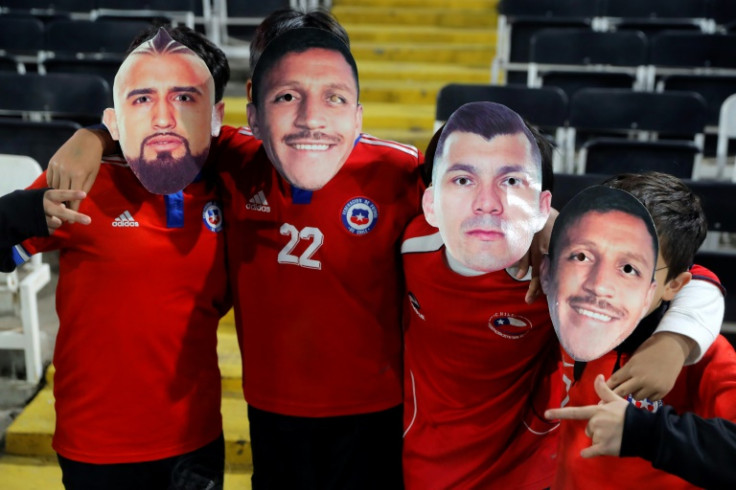 Chilean football fans don masks of their favorite players