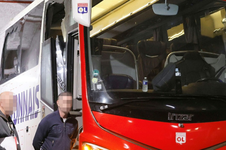 The smashed window of Lyon's team bus is visible