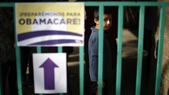 A boy waits in line at a health insurance enrollment 