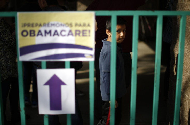 A boy waits in line at a health insurance enrollment 