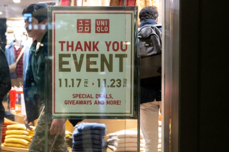 A person walks past a sales advertisement at Uniqlo Store