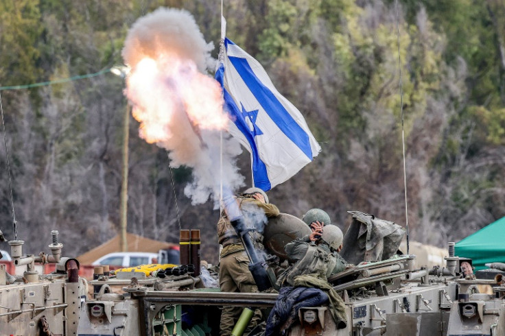 Israeli soldiers fire mortar rounds from an armored vehicle