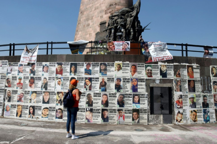 A Mexican mother looks at a wall of missing person notices in the western city of Guadalajara