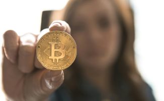 Woman holding a Bitcoin token