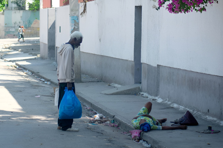 An elderly woman, who was shot in the foot, lies 