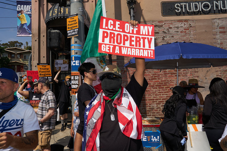 Masked man protests against ICE immigration raids in Los Angeles