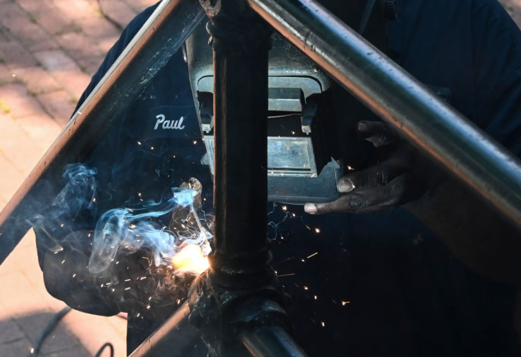 A welder repairs an iron stair case