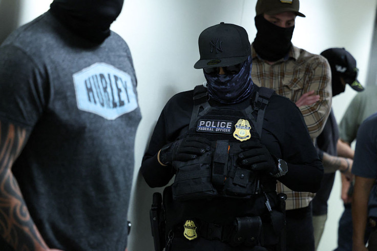Federal agents wait outside a courtroom at New York Federal