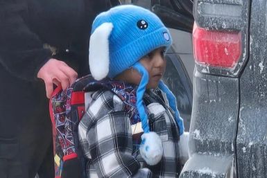 Liam Ramos stands with an immigration agent