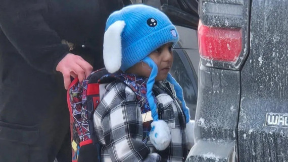 Liam Ramos stands with an immigration agent