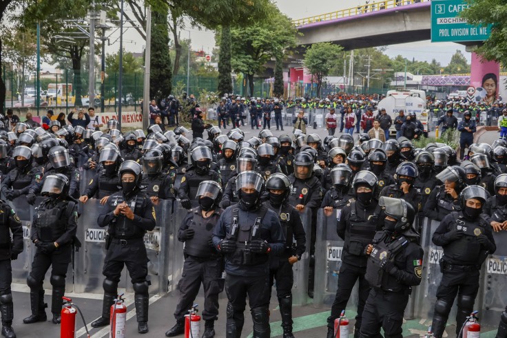 Members of the police block the way.
