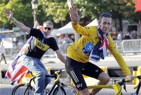 Sky Procycling rider and leader's yellow jersey Bradley Wiggins of Britain and Sky Procycling Sport director Sean Yates (L) celebrate with British national flags on the Champs Elysees after the final stage of the 99th Tour de France cycling race in Paris,