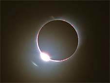 The sun is beginning to move out from behind the moon in this picture of a total eclipse.